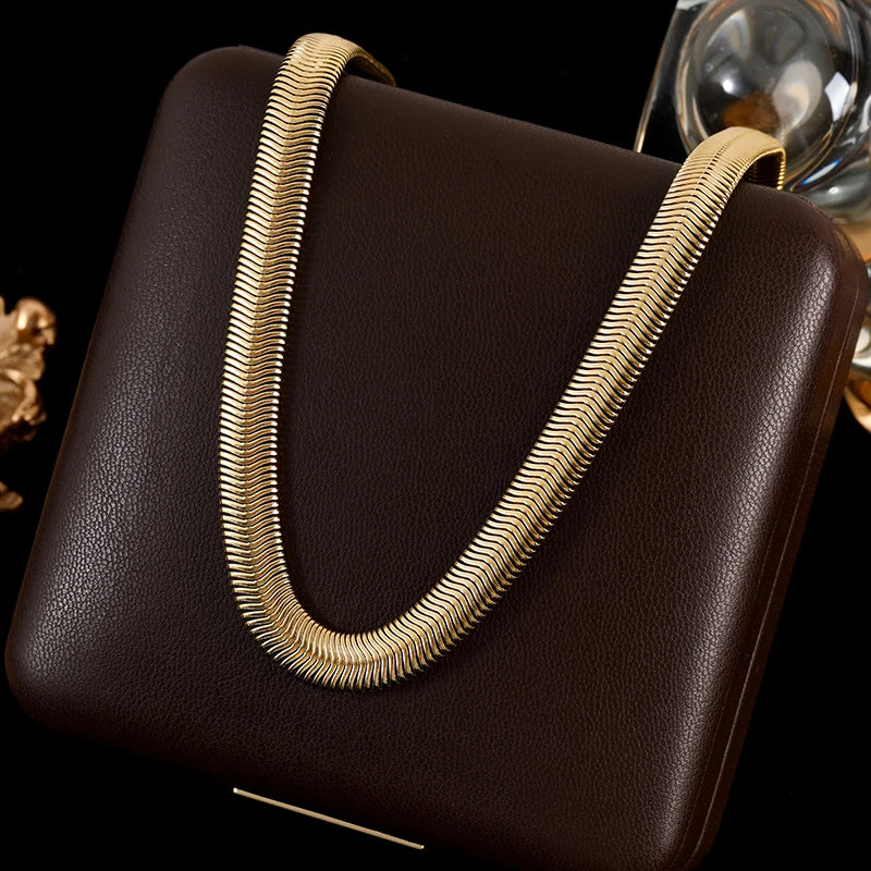 Brown handbag with a gold handle on a black background