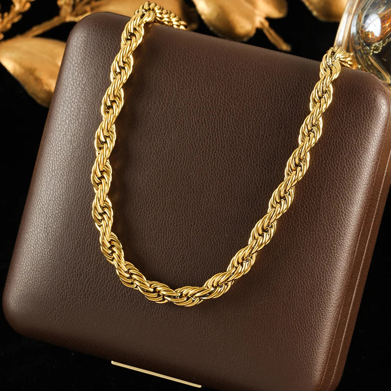 Gold rope chain on a brown leather surface with a blurred floral background
