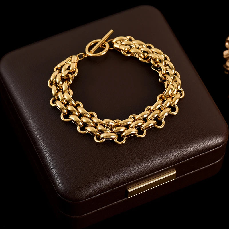 Gold chain bracelet on a dark brown jewelry box