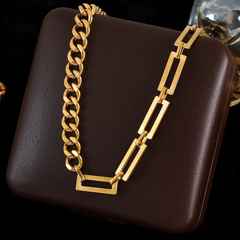 Gold chain necklace on a brown leather surface
