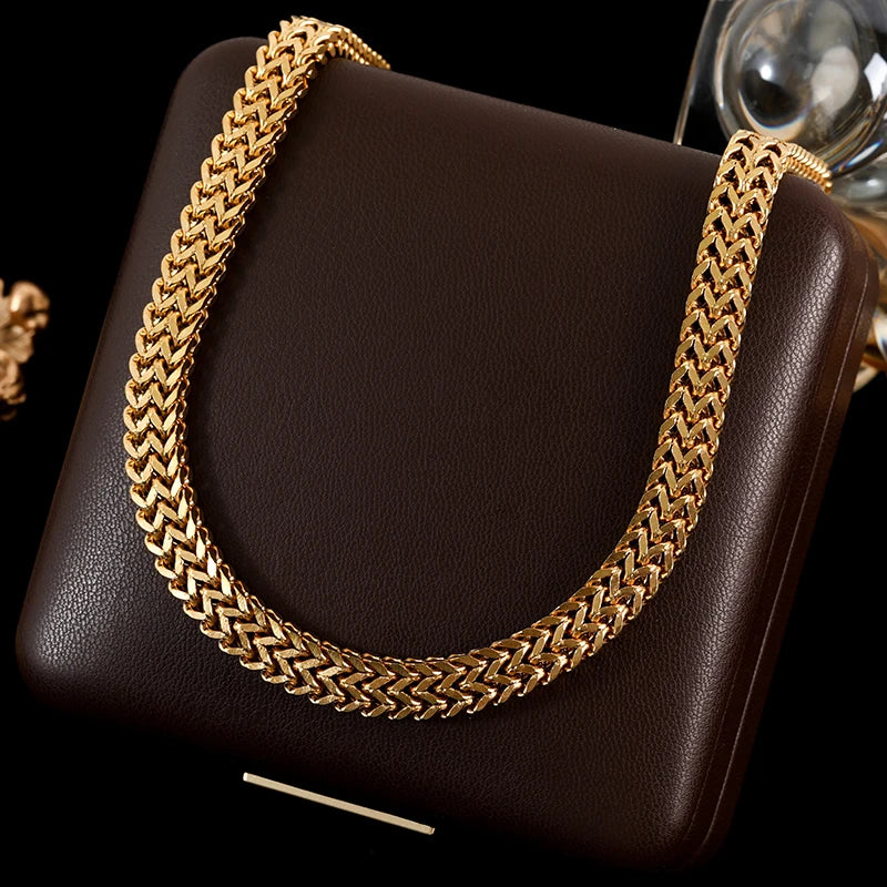 Gold chain necklace on a brown leather bag with a blurred background