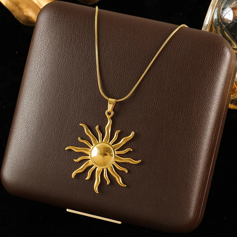 Gold sun pendant necklace on a brown leather surface