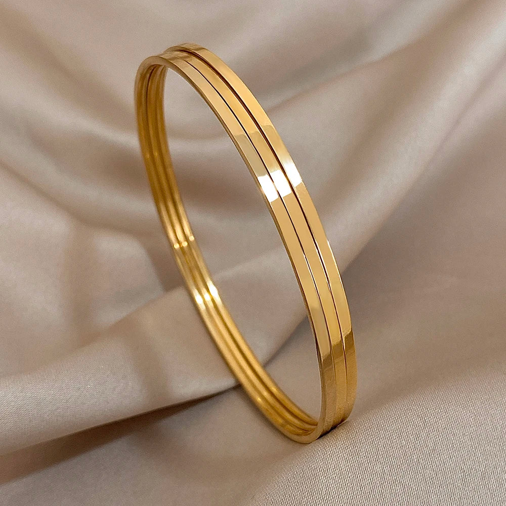 Gold bangle on a beige fabric background