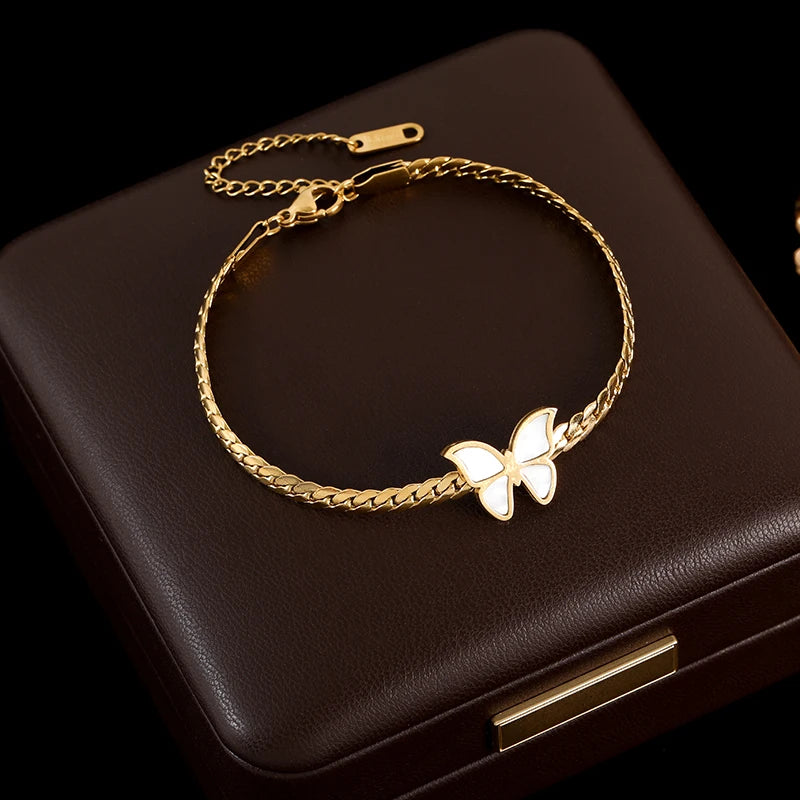 Gold bracelet with a butterfly charm on a dark brown box