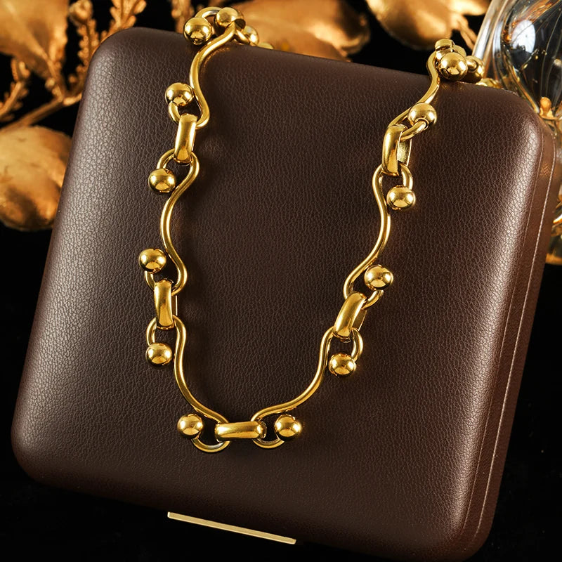 Brown leather handbag with gold chain handle on a dark background