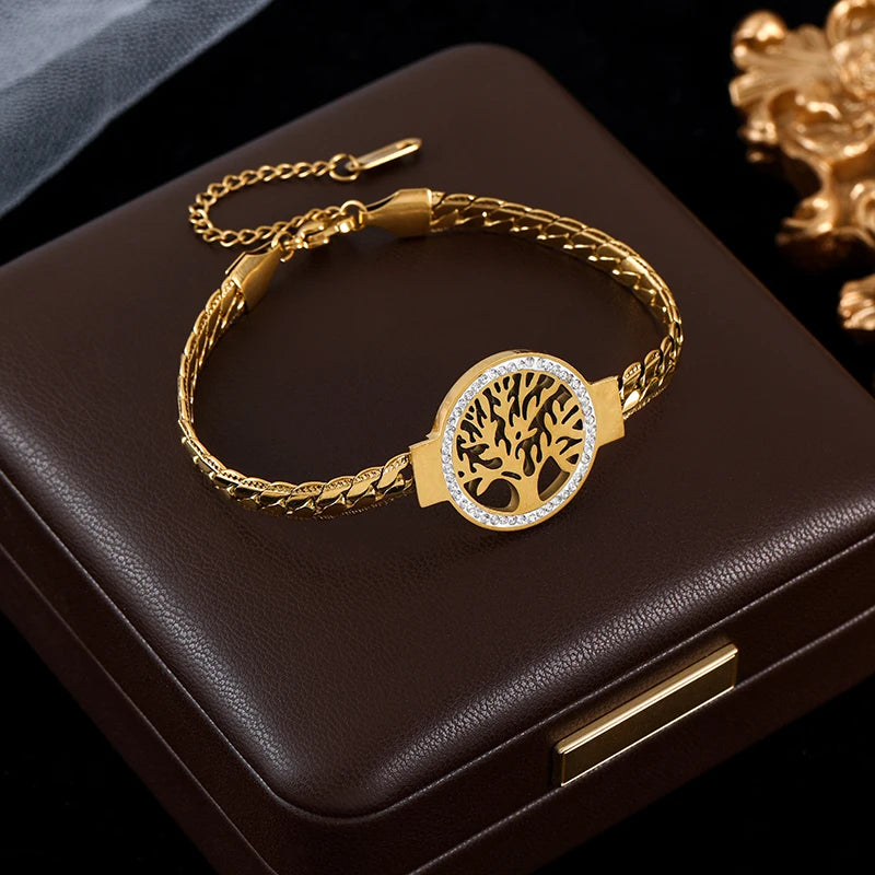 Gold bracelet with tree of life design on a dark surface