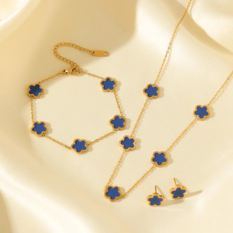 Gold necklace with blue flower pendants on a beige background