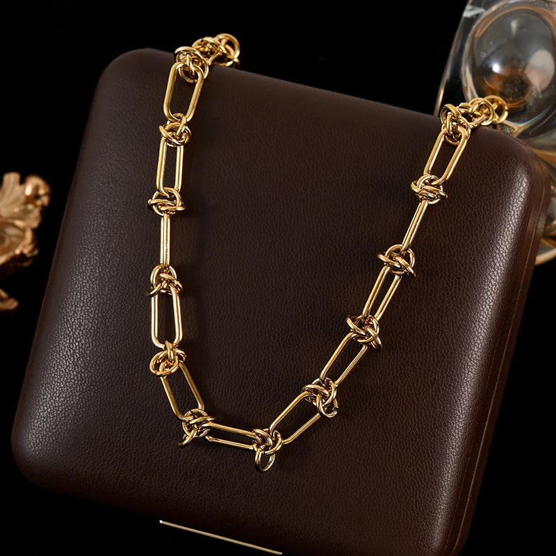 Gold chain necklace on a dark brown surface