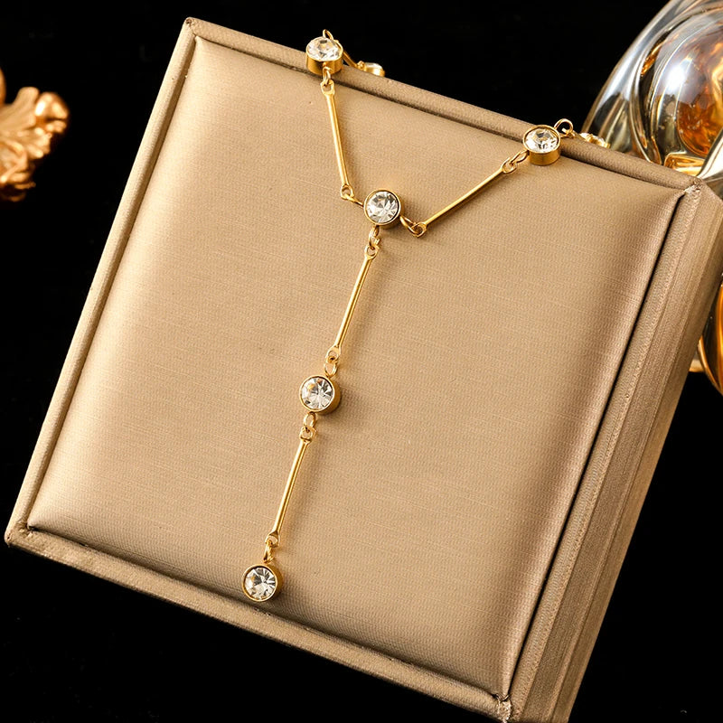 Gold necklace with crystals on a beige jewelry box