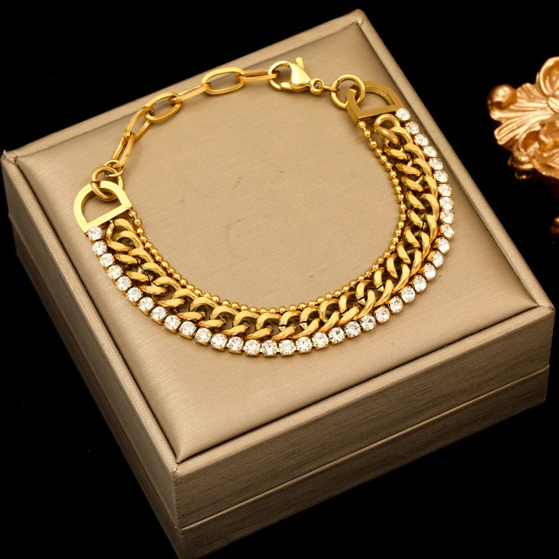 Gold bracelet with embedded stones on a beige jewelry box