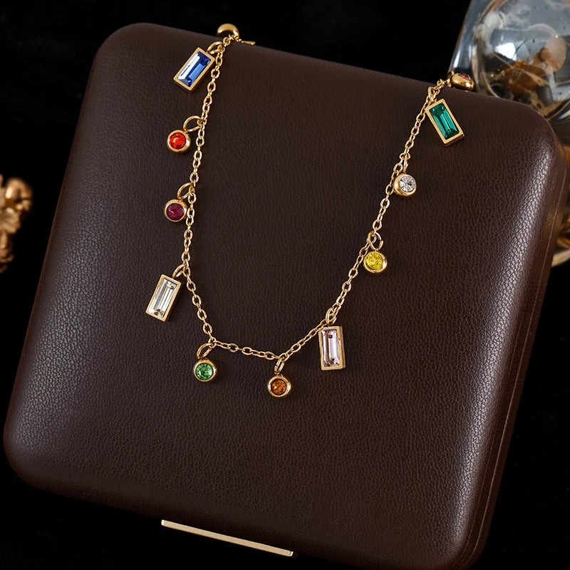 Gold necklace with colorful gemstones on a brown leather surface