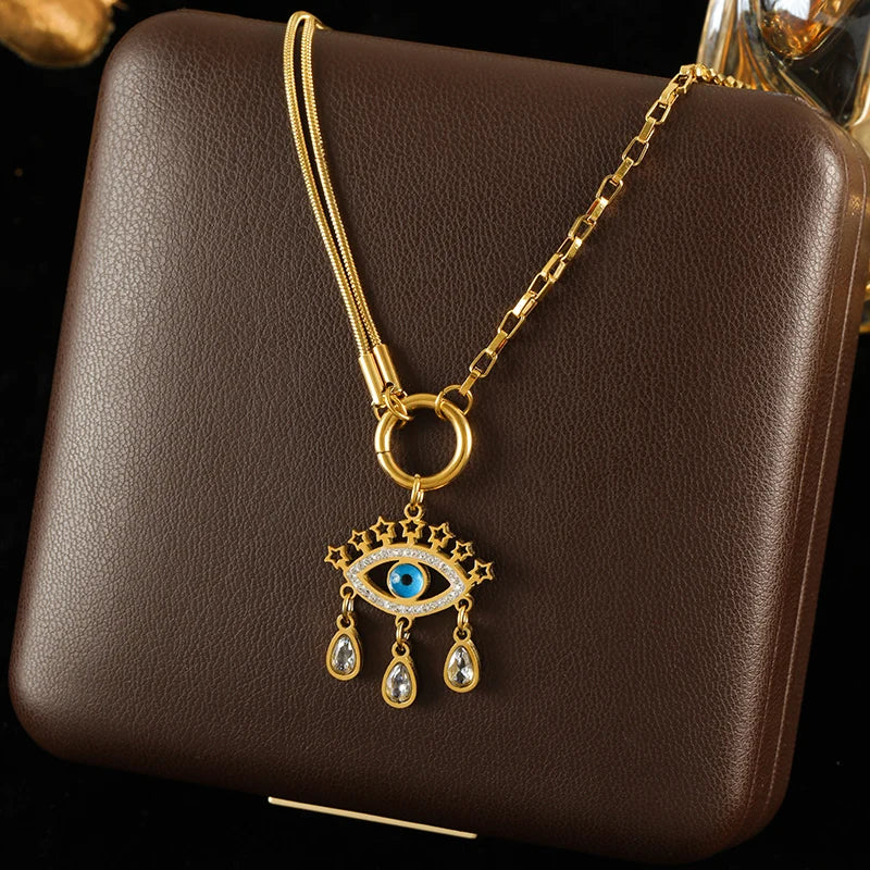 Gold necklace with an eye-shaped pendant on a brown leather surface